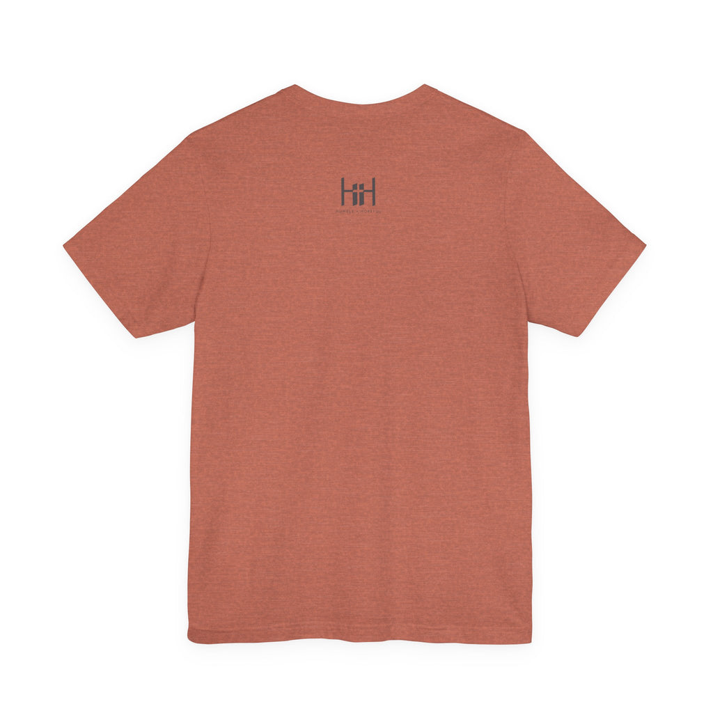 Back view of an orange t-shirt on a white background with a 'Humble + Hopeful' logo on it