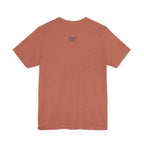 Back view of an orange t-shirt on a white background with a 'Humble + Hopeful' logo on it
