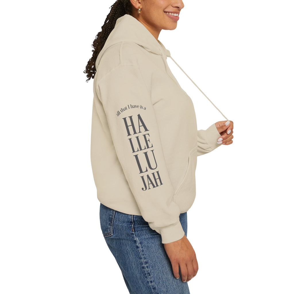 Person wearing a sand colored hoodie with 'Hallelujah' on the sleeve on a white background