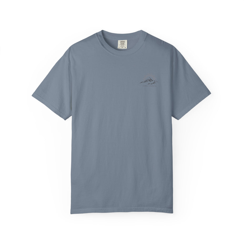 Blue jean color t-shirt with small mountain design and 'humble and hopeful' text on a white background.