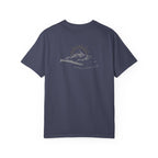 A denim color t-shirt with a mountain with a rising sun and the Way, the Truth, the Life text printed underneath the graphic on a white background.