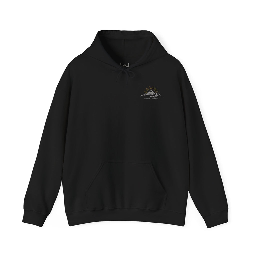 Black pullover hoodie with a small mountain and humble and hopeful text on a white background.