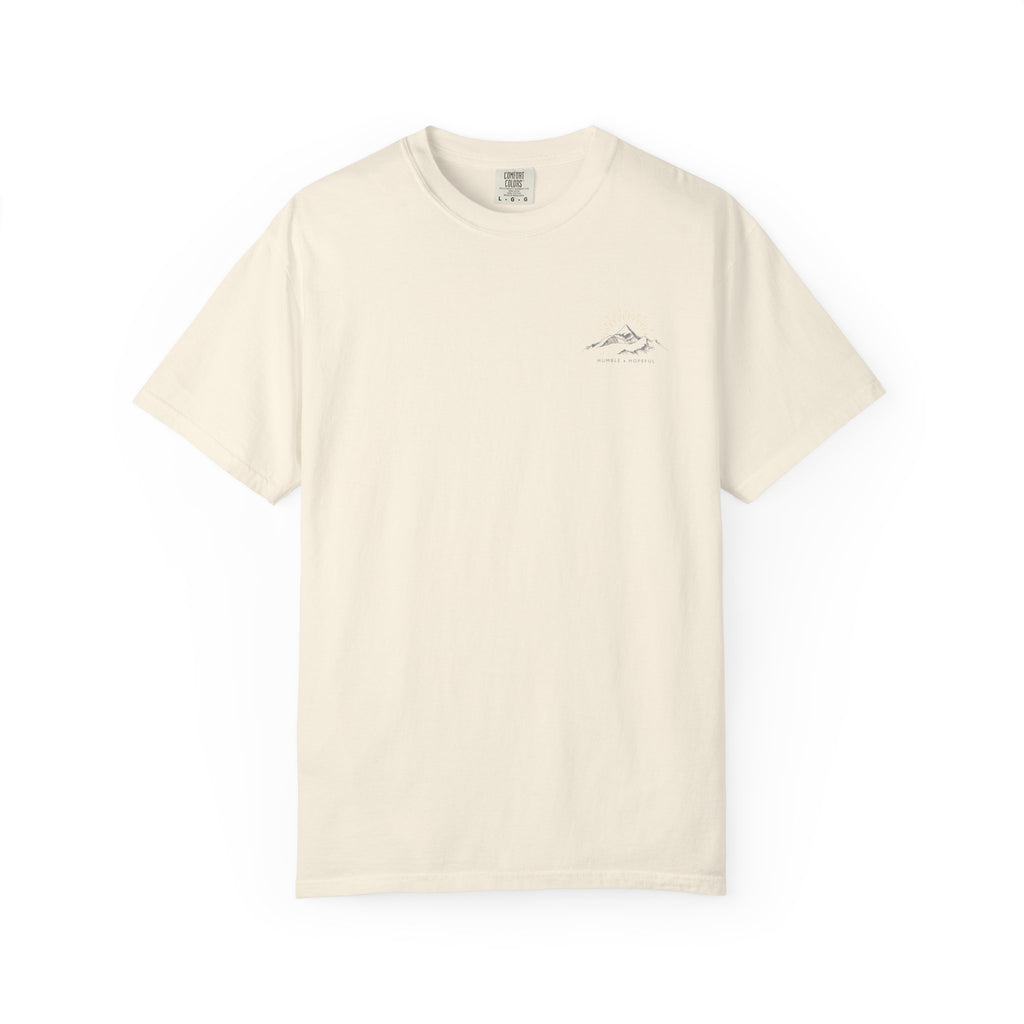 Ivory t-shirt with small mountain design and 'humble and hopeful' text on a white background.