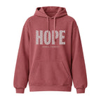 A crimson pullover hoodie with a front kangaroo pocket and drawstrings. The word 'HOPE' is printed across the chest in a white patterned font, with the words 'HUMBLE + HOPEFUL' printed underneath in a smaller font.