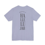 A light periwinkle blue short-sleeve t-shirt shown from the back, featuring a vertical graphic print that reads 'all that I have is a HÄLLELUJAH' in dark gray lettering.