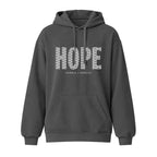 A dark gray pullover hoodie with a front kangaroo pocket and drawstrings, featuring a graphic on the chest that spells 'HOPE' in a patterned white font, with 'HUMBLE = HOPEFUL' printed underneath.