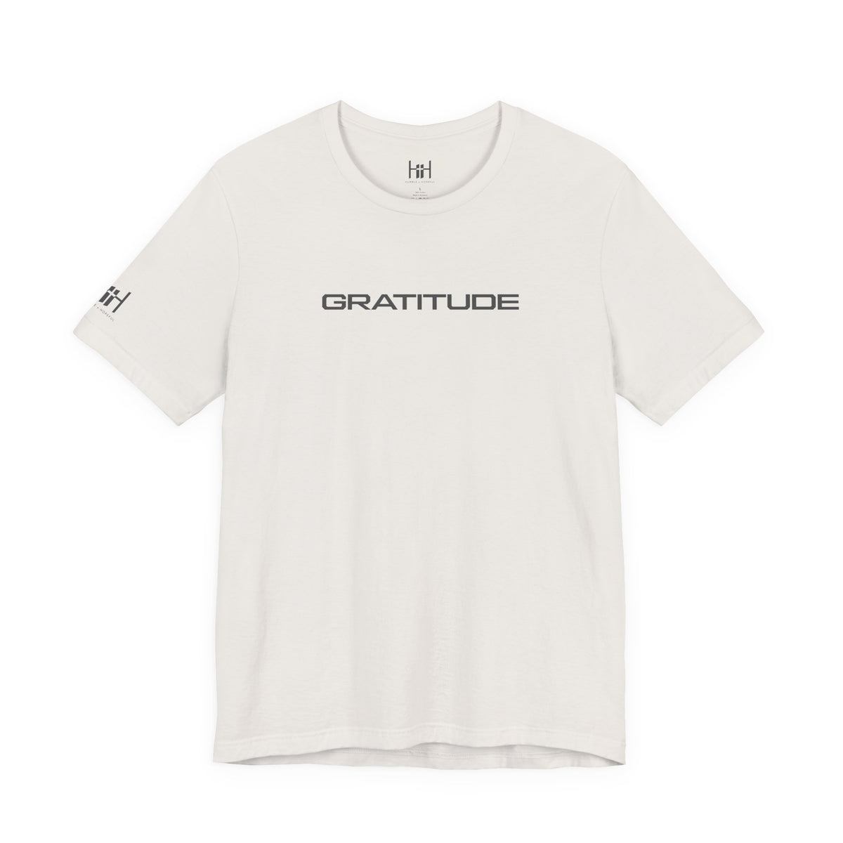 An off-white crewneck t-shirt with 'GRATITUDE' printed in black sans-serif font across the chest, featuring a small matching 'HH' logo on the left sleeve, displayed on a clean white background.